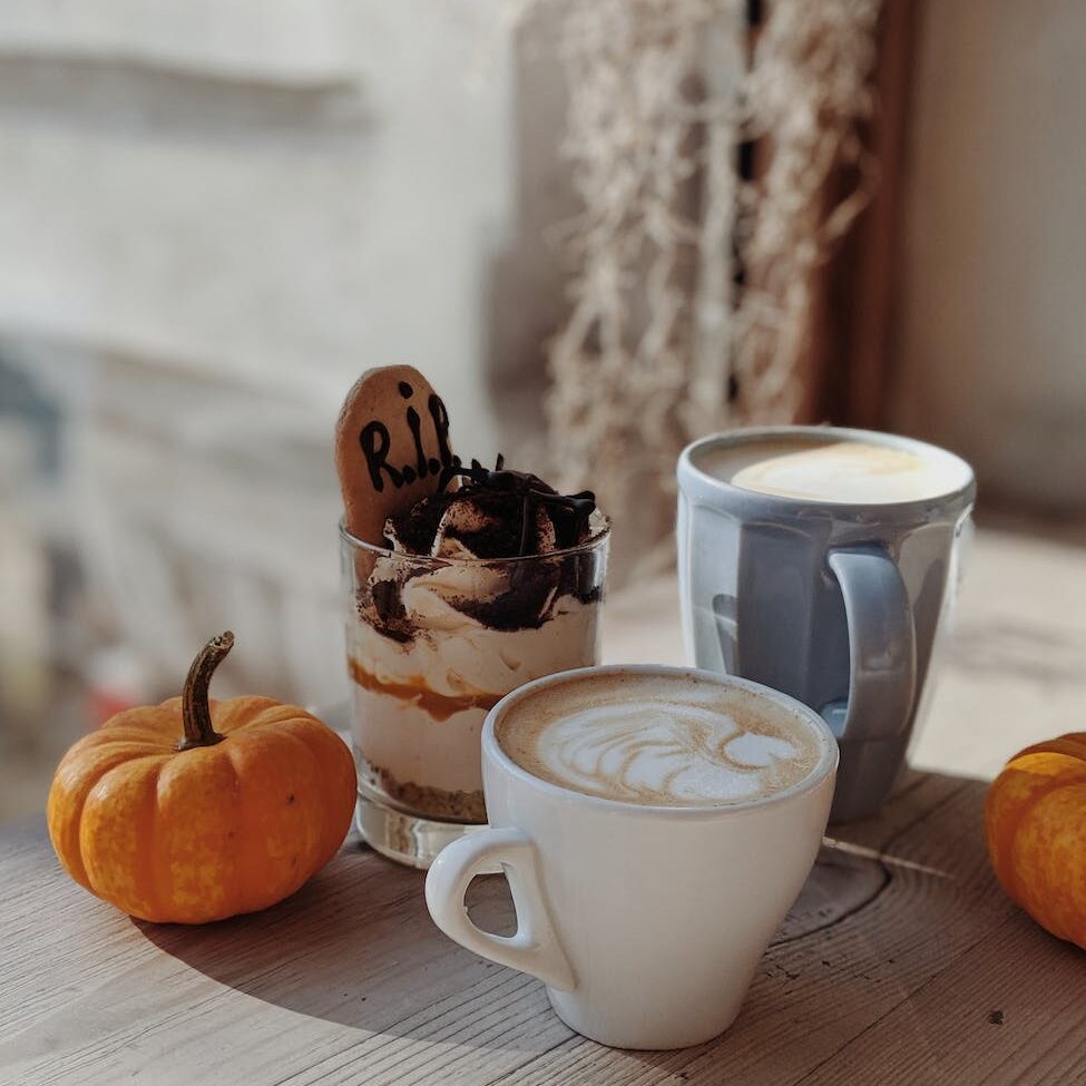 two white and blue mugs beside drinking glass